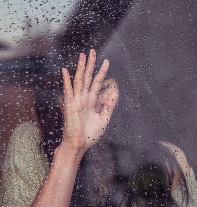 Девушка плачет у окна