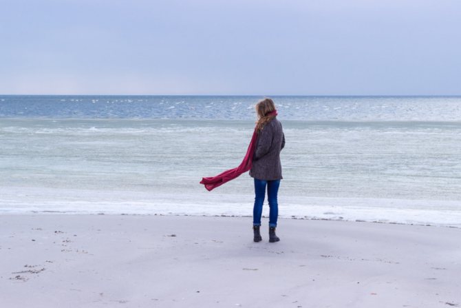 Девушка с депрессией на фоне холодного моря