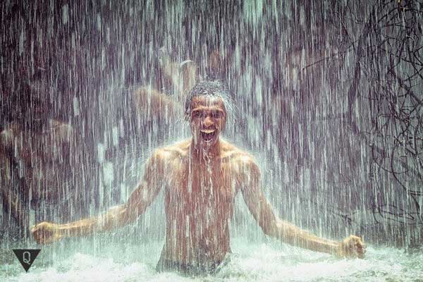 Мужчина купается в водопаде