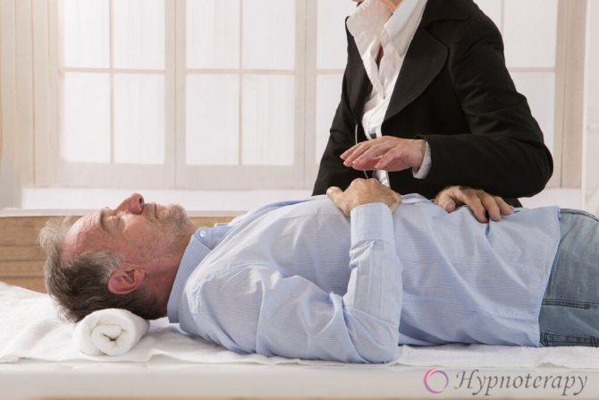 Мужчина пожилых лет лежит на приёме у гипнотерапевта с закрытыми глазами и сложенными руками