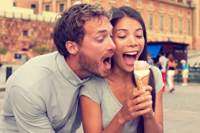 Парень и девушка кушают мороженое