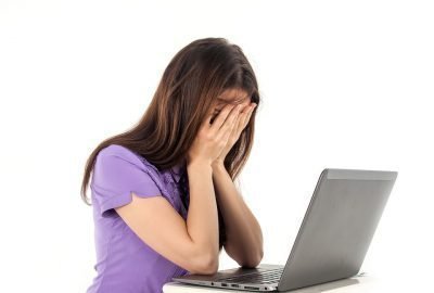 Расстроенная девушка перед ноутбуком