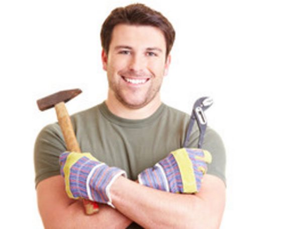 Улыбающийся мужчина в строительных перчатках с молотком и плоскогубцами в руках