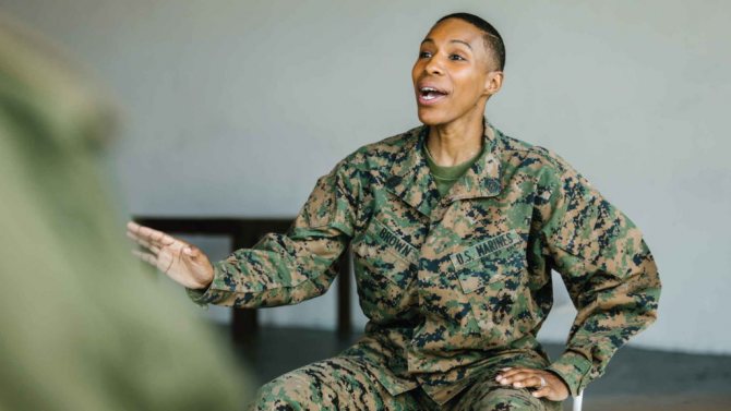 Женщина военная сидит и жестикулирует